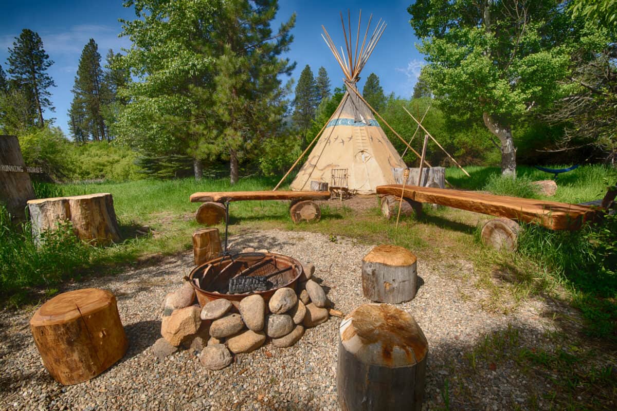 Authentic Teepee set in a beautiful campsite with a huge firepit and custom log benches.