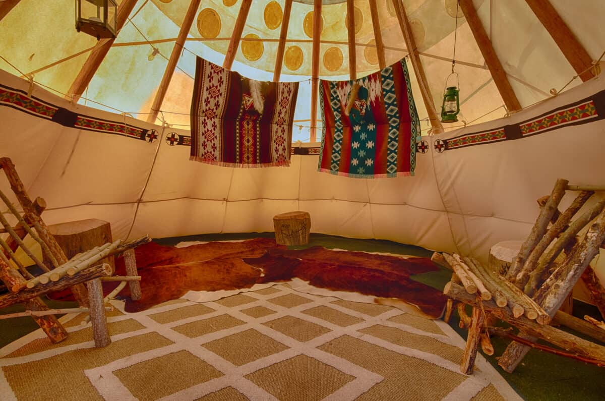 Interior view of authentic teepee for rent in Garden Valley, Idaho. Decorated with Indian artifacts and custom log furniture.